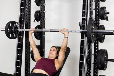 Athlete benching on the front of a rack mounted Smith Machine